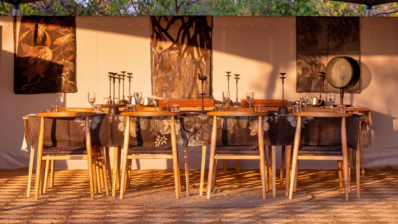 Camp Maru: Dinner Afrikarma, Afrikarma Safaris, Afrikarma Safaris. Wildnis. Hautnah., Afrikarma.de, Dinner, Esstisch, Sonnenuntergang, Stühle, Camp Maru, Okavango Hidden Gems