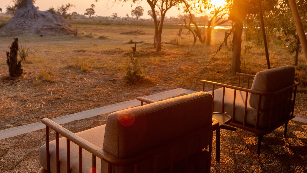 Camp Maru: Sonnenaufgang Afrikarma, Afrikarma Safaris, Afrikarma Safaris. Wildnis. Hautnah., Afrikarma.de, Bäume, Natur, Sessel, Sonnenaufgang, Terrasse, Tisch, Camp Maru, Okavango Hidden Gems
