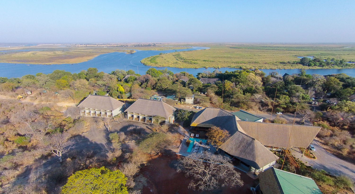 Chobe Bush Lodge: Die Anlage aus der Luft africa, afrika, afrikarma, babysitting, bilder, boot, bootsfahrt, botsuana, botswana, buchen, buchung, büffel, chobe, chobe bush lodge, chobe national park, chobe river, chobe-nationalpark, elefant, familien, galerie, halbpension, information, informieren, kasane, kinder, kutur, leopard, löwe, national park, nationalpark, pirschfahrt, reise, reisen, reiseveranstalter, safari, southern, südliches, under one botswana sky, urlaub, victoria falls, viktoria-fälle, www.afrikarma.de, anlage, ansicht, central facilities, hauptgebäude, landschaft, luftaufnahme, luftbild, main building, zentrale Einrichtungen