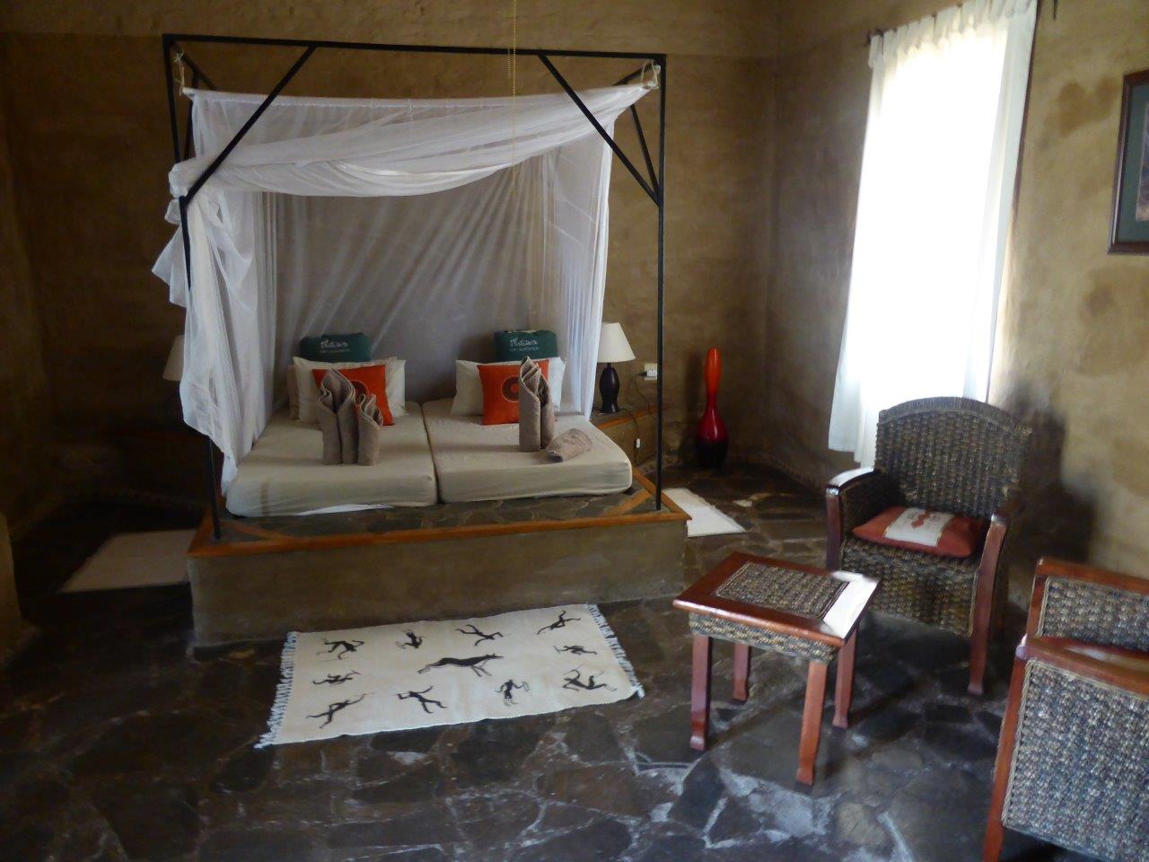 Fort Sesfontein: Im Zimmer liegen Handtücher bereit Damaraland, Fort Sesfontein, Kaokoveld, Namibia, Hoanib, Trockenfluss, Doppelbett, Gästeunterkunft, Gästezimmer, Himmelbett, Steinboden, Zimmer, Afrikarma, Afrikarma Safaris, Afrikarma Safaris – Wildnis. Hautnah., afrikarma.de