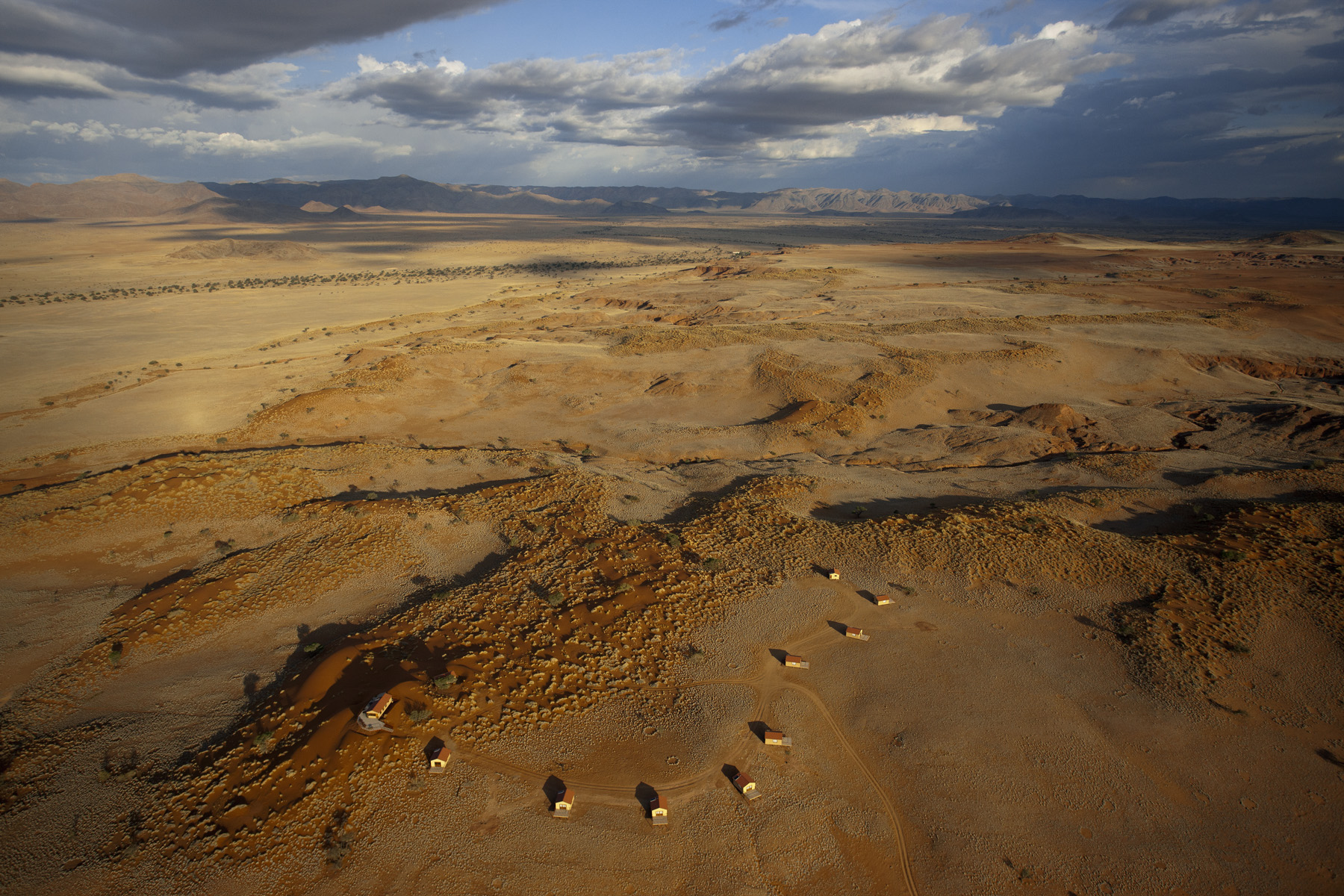 Namib Dune Star Camp: Luftbild Anlage, Cabins, Hang, Hauptgebäude, Landschaft, Luftaufnahme, Luftbild, Gondwana Collection, Namib Dune Star Camp, Namibia, Namib-Naukluft National Park, Naukluft Mountain Zebra Park, Wüste, Namib, Namibwüste, Namib Sea Sand, Namib-Sandmeer, UNESCO, Welterbe, Afrikarma, Afrikarma Safaris, Afrikarma Safaris – Wildnis. Hautnah., afrikarma.de