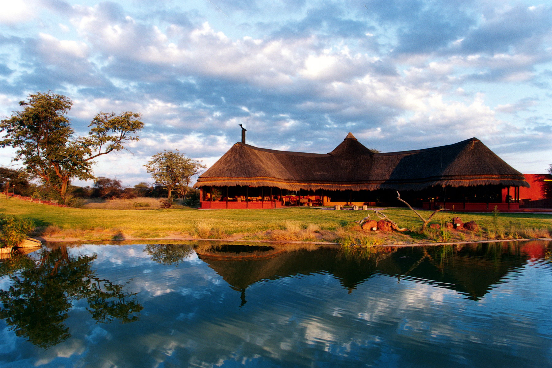 Africat, Africat Foundation, Afrika, Afrikarma, Afrikarma.de, Auswilderung, Conservation, Funktracking, Hanssen, Hanssen Family, Namibia, Okonjima, Okonjima Naturreservat, Okonjima Reservat, Omboroko Mountains, Omboroko-Berge, Pirschfahrt, Raubkatzen, Raubtiere, Reise, Reiseveranstalter, Safari, Tierschutz, Tracking, Urlaub, Waterberg Plateau, Waterberg-Plateau, Ansicht, Hauptgebäude, Himmel, Lapa, Main Building, Spiegelung, Stimmung, Wasser, Wasserstelle, Wolken