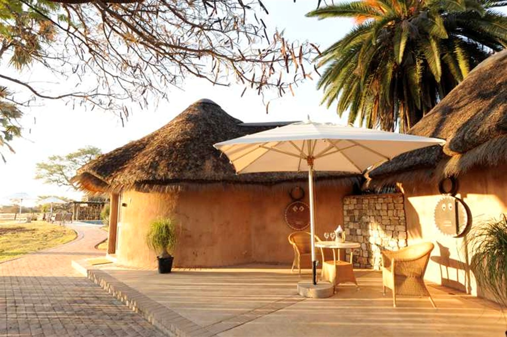 Onguma Bush Camp: Waterhole Chalet - Deck Etosha Nationalpark, Namutoni Gate, Omuramba Owambo, Onguma Bush Camp, Onguma Reserve, Deck, Palmen, Sonnenschirm, Afrikarma, Afrikarma Safaris, afrikarma Safaris - Wildnis Hautnah, Afrikarma.de