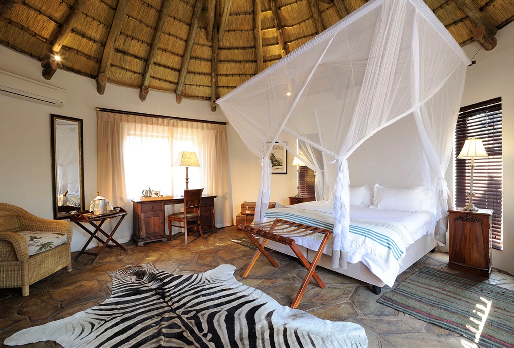 Etosha, Etosha Nationalpark, Lodge, Onguma, Onguma Etosha Aoba Lodge, Onguma Private Game Reserve, Onguma Reserve, Explorer Bungalow, Doppelbett, Korbsessel, Moskitonetz, Reetdach, Teppich, Zebrafell, Afrikarma, Afrikarma Safaris, Afrikarma Safaris - Wildnis Hautnah, Afrikarma.de