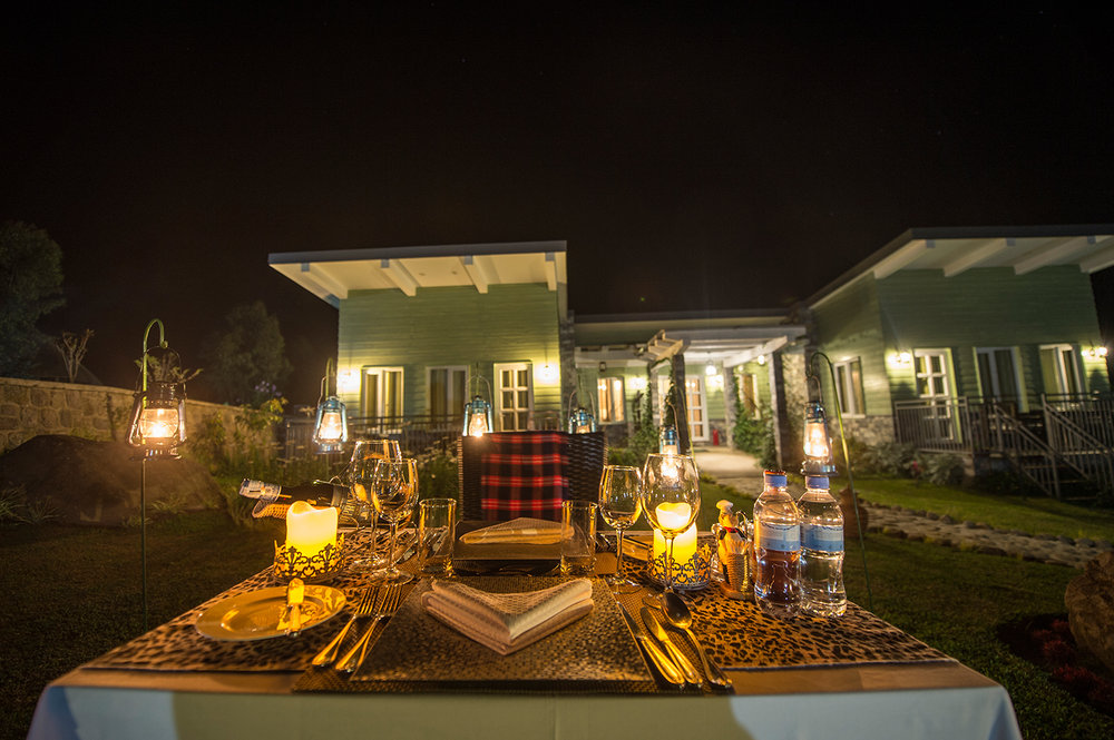 Amakoro Songa Lodge: Abendessen draußen Abendessen, Bäume, Gästeunterkunft, Tisch, Amakoro Songa Lodge, Gorilla Tracking, Volcanoes National Park, Afrikarma, Afrikarma Safaris, Afrikarma Safaris. Wildnis. Hautnah., afrikarma.de