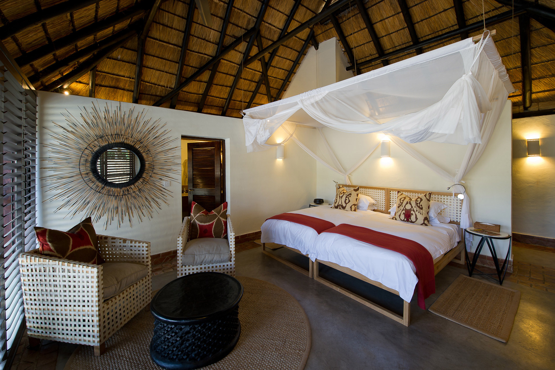 Mfuwe Lodge: Doppelbett Bushcamp Company, Luangwa River, Luangwa-Tal, Mfuwe Lodge, Paul Allen, Sambia, South Luangwa National Park, Walking Safari, Doppelbett, Gästechalet, Moskitonetz, Sessel, Afrikarma, Afrikarma Safaris, Afrikarma.de