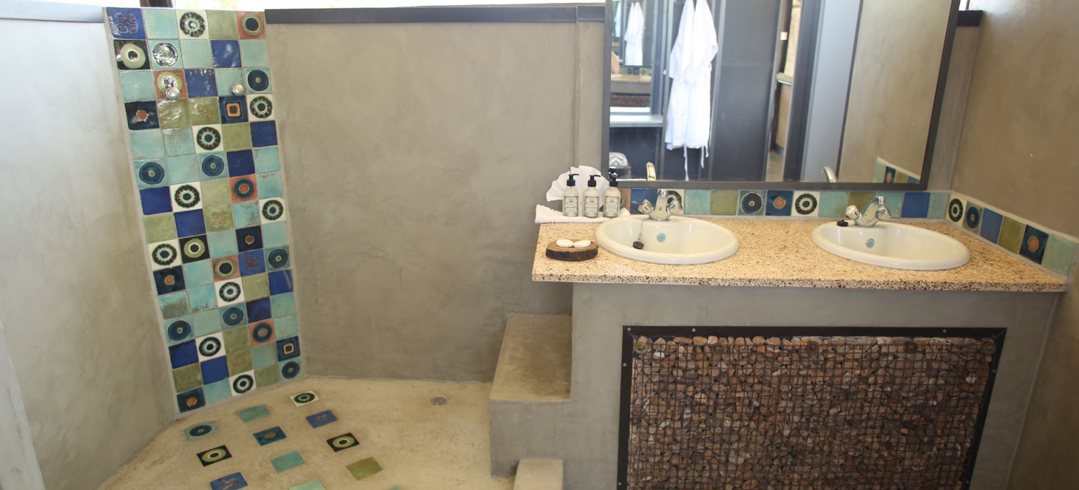 Afrikarma, Afrikarma Safaris, Afrikarma Safaris. Wildnis. Hautnah., Afrikarma.de, Kavinga Safari Camp, Mana Pools National Park, Doppelwaschtisch, Dusche, Fliesen, Gästebad