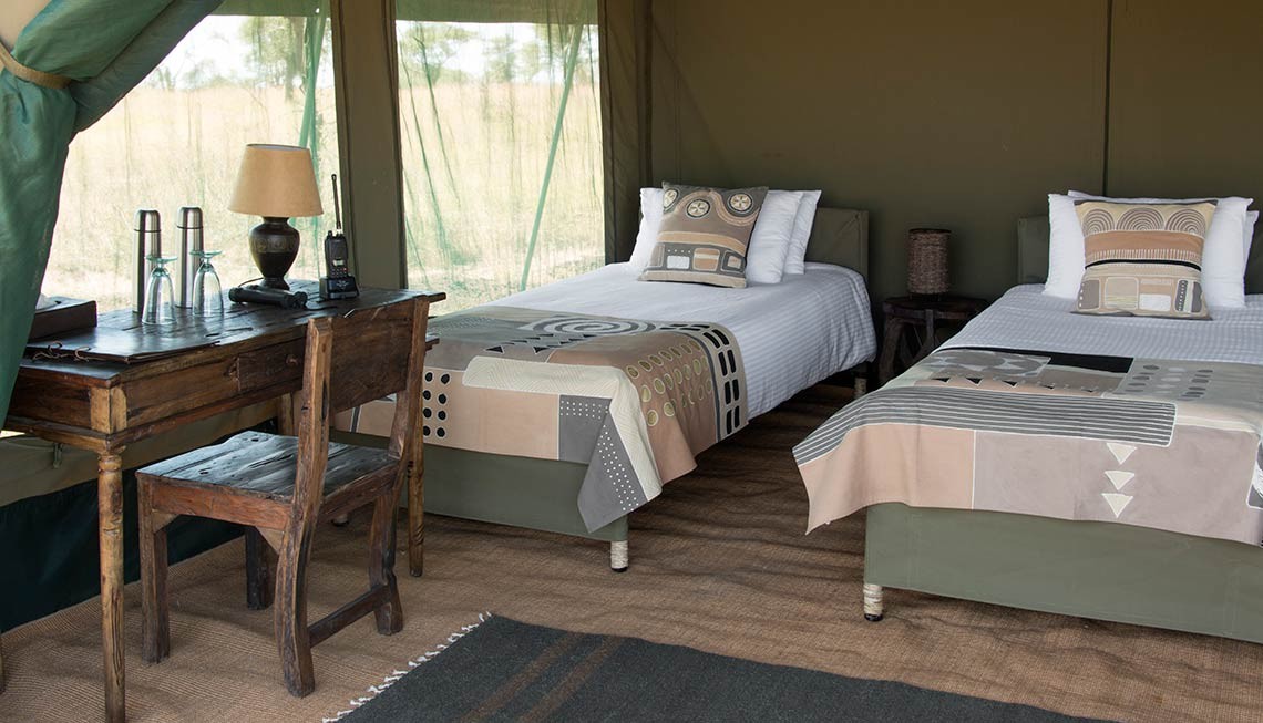 Chaka Camp: Der Schlafbereich mit Sekretär Chaka Camp, Große Migration, Große Wanderung, Mara River, Masek Lake, Ndutu Lake, Ngorongoro Conservation Area, Serengeti, Tansania, Wandercamp, Bett, Gästezelt, Schlafbereich, Sekretär, Afrikarma, Afrikarma Safaris, Afrikarma Safaris – Wildnis. Hautnah., afrikarma.de