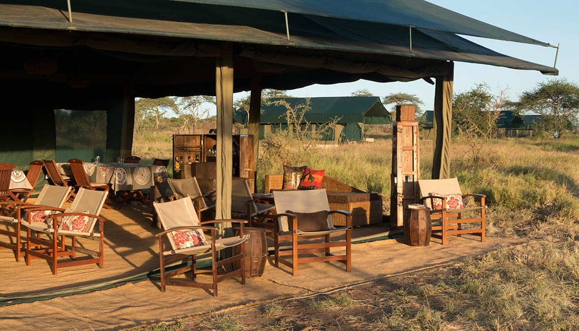 Chaka Camp: Die offene Lounge Area Chaka Camp, Große Migration, Große Wanderung, Mara River, Masek Lake, Ndutu Lake, Ngorongoro Conservation Area, Serengeti, Tansania, Wandercamp, Graslandschaft, Lounge Area, Sessel, Sofa, Afrikarma, Afrikarma Safaris, Afrikarma Safaris – Wildnis. Hautnah., afrikarma.de