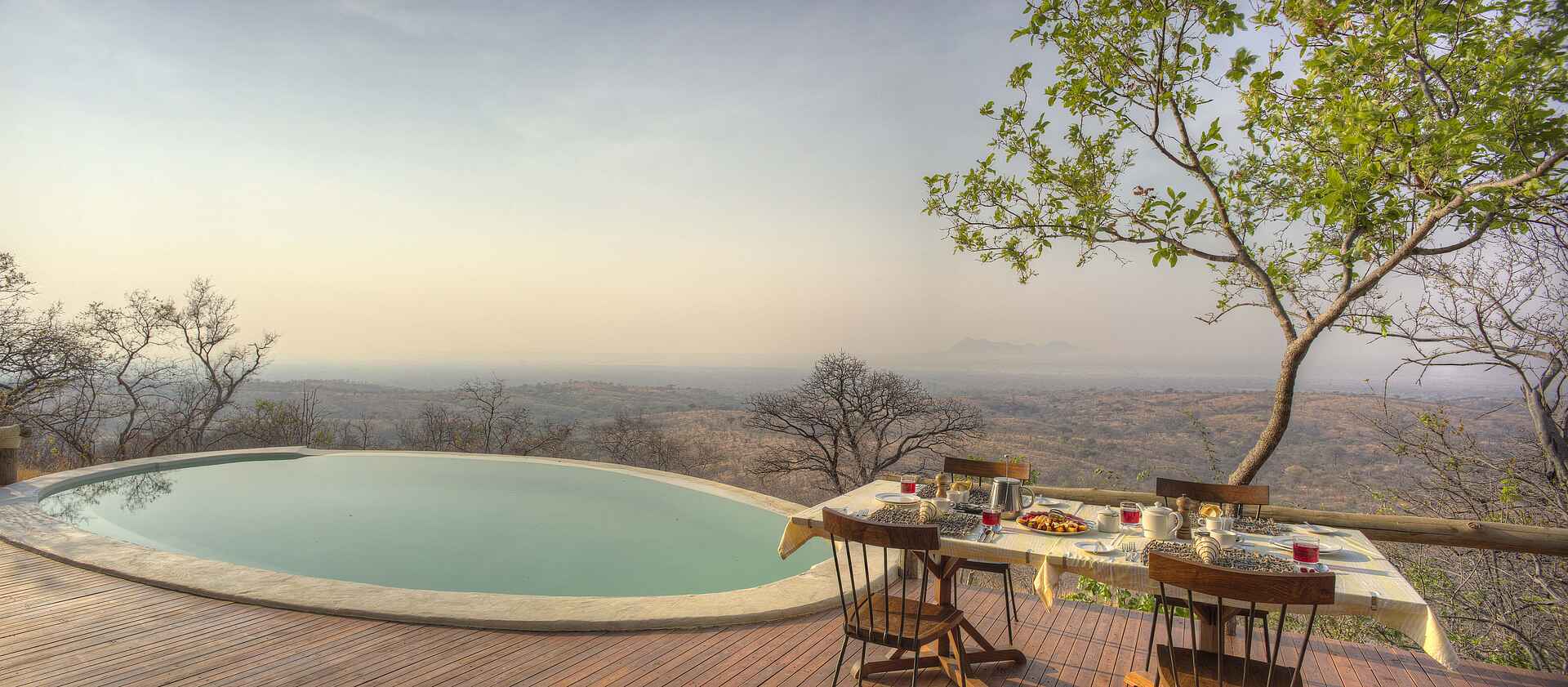Ikuka Safari Camp: Speisen unter freiem Himmel mit Rundumblick Chloe Sheridan-Johnson, Ikuka Safari Camp, Mark Sheridan-Johnson, Ruaha National Park, Gedeckter Tisch, Pool, Sonnendeck, Zentrale Einrichtungen, Afrikarma, Afrikarma Safaris, Afrikarma Safaris – Wildnis. Hautnah., afrikarma.de