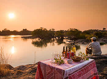 KaingU Safari Lodge: Sundowner auf Felsen am Fluss