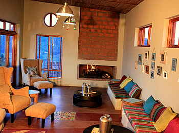 Chameleon Hills Lodge: Die gemütliche Lounge mit offenem Kamin und Lehnsessel