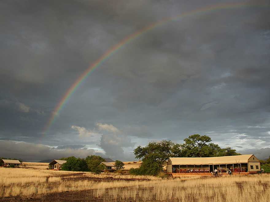Desert Rhino Camp: Wildes Wüstenwetter mit Regenbogen Desert Rhino Camp: Wildes Wüstenwetter mit Regenbogen