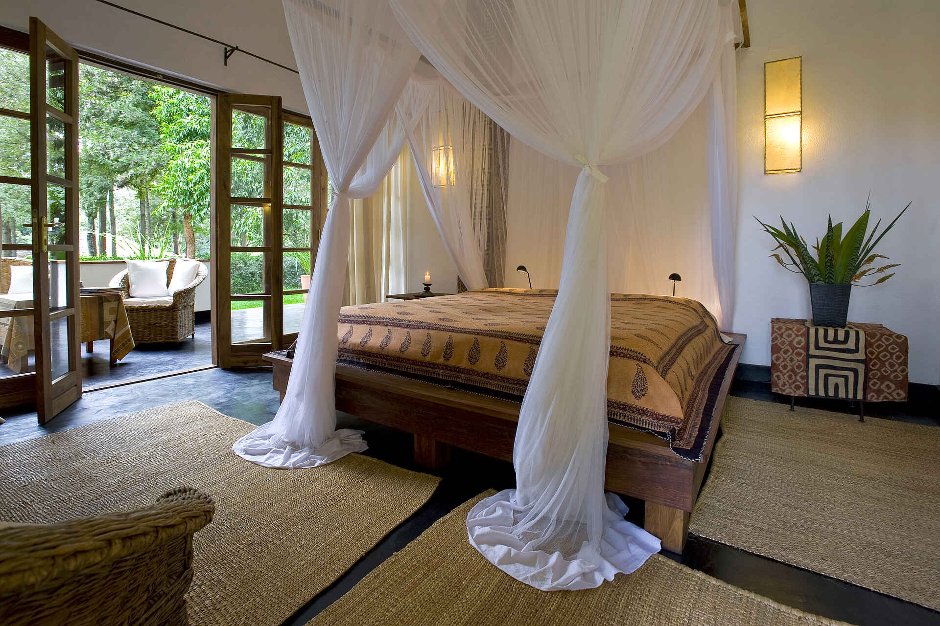 Plantation Lodge: Doppelbett und Blick zur Terrasse Ngorongoro-Krater, Plantation Lodge, Balkon, Doppelbett, Gästechalet, Moskitonetz, Teppich, Veranda, afrikarma, afrikarma Safaris, afrikarma Safaris - Wildnis. Hautnah., afrikarma.de