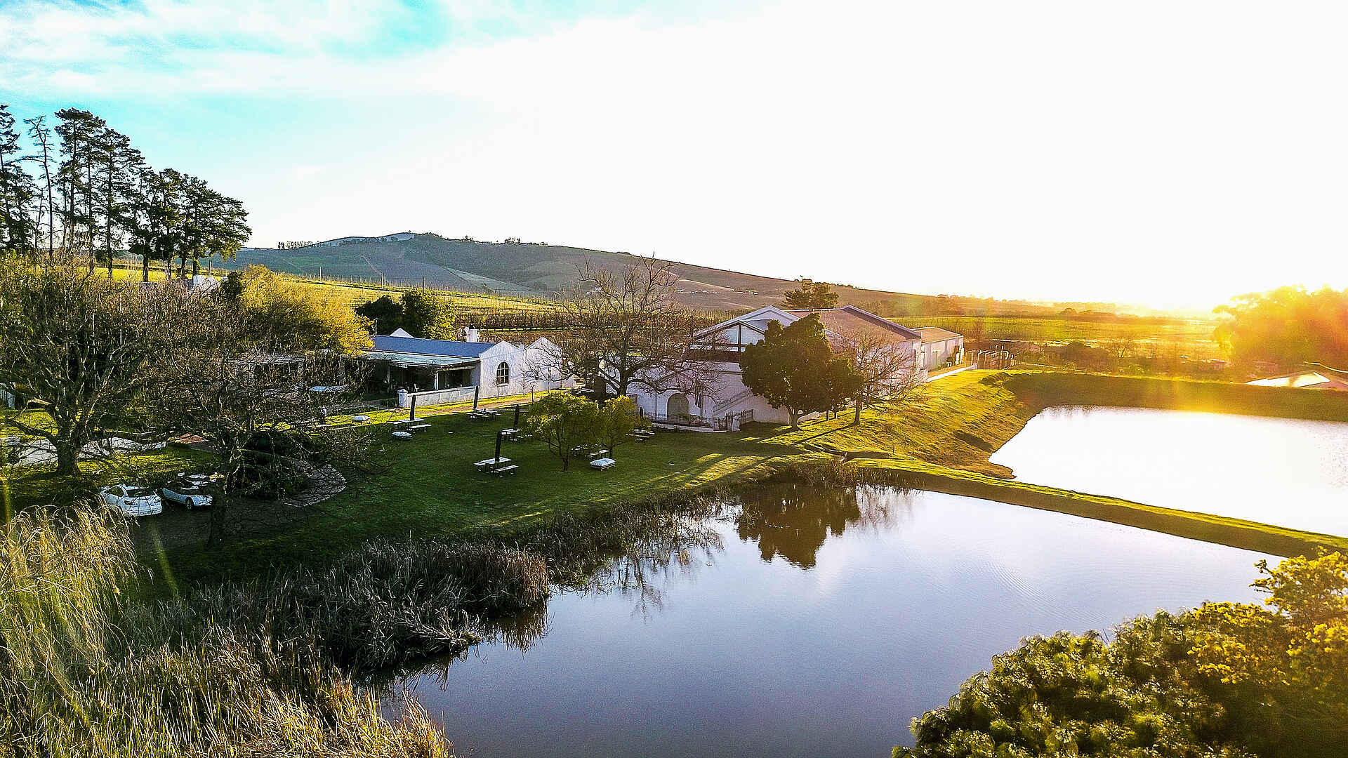 Afrikarma, Afrikarma Safaris, Afrikarma Safaris - Wildnis. Hautnah., Afrikarma.de, L'Avenir Country Lodge, Autos, Bäume, Büsche, Häuser, Wolken, Zwei Dämme