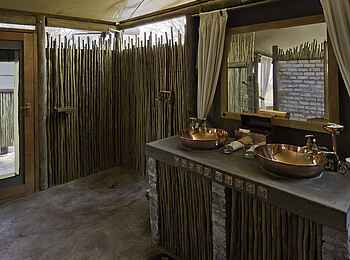 Little Makalolo Camp: Gästebad und Durchgang zur Außendusche Little Makalolo Camp: Gästebad und Durchgang zur Außendusche