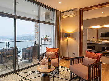 Lux Lake Kivu Hotel: Familiensuite Wohnbereich mit Blick ins Badezimmer und auf den Balkon