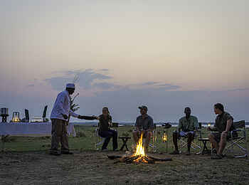 Ruckomechi Camp: Sundowner am Lagerfeuer Ruckomechi Camp: Sundowner am Lagerfeuer