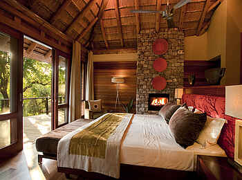 Morukuru River House: Schlafzimmer mit King-Size-Bett und Kamin Morukuru River House: Schlafzimmer mit King-Size-Bett und Kamin