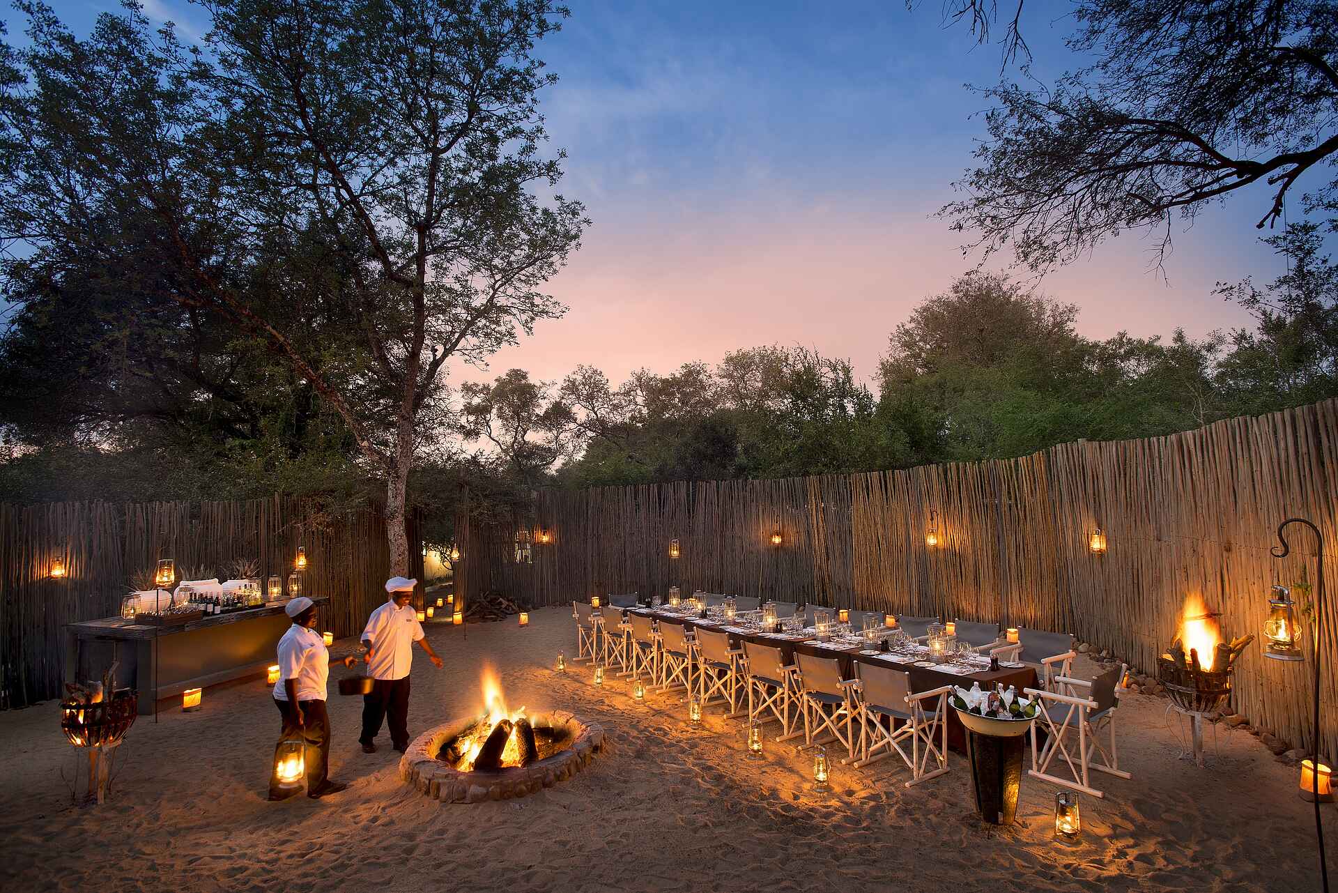 Dulini Private Game Reserve, Dulini River Lodge, Kruger National Park, Mabrak River, Sabi Sands Game Reserve, Südafrika, Boma, Dinner, Feuerstelle, Freier Himmel, Gedeckter Tisch, Gemeinsam, Outdoor, Sonnenuntergang, Tafel, Afrikarma, Afrikarma Safaris, Afrikarma Safaris – Wildnis. Hautnah., afrikarma.de, Sand River