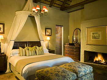 &Beyond Ngala Safari Lodge: Bett und Kamin in den Cottages