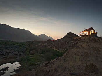 Okahirongo River Camp: Hauptgebäude am Abend Okahirongo River Camp: Hauptgebäude am Abend