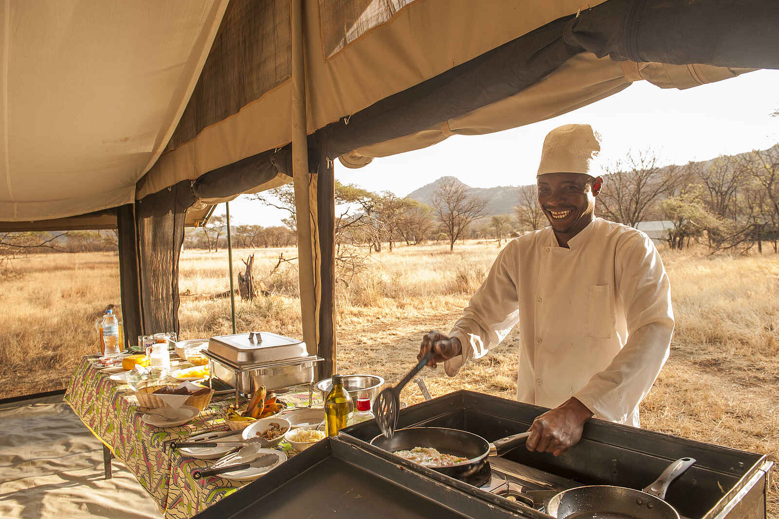 Serengeti Kati Kati Tented Camp: Koch beim Zubereiten eines Omelettes Serengeti Kati Kati Tented Camp: Koch beim Zubereiten eines Omelettes