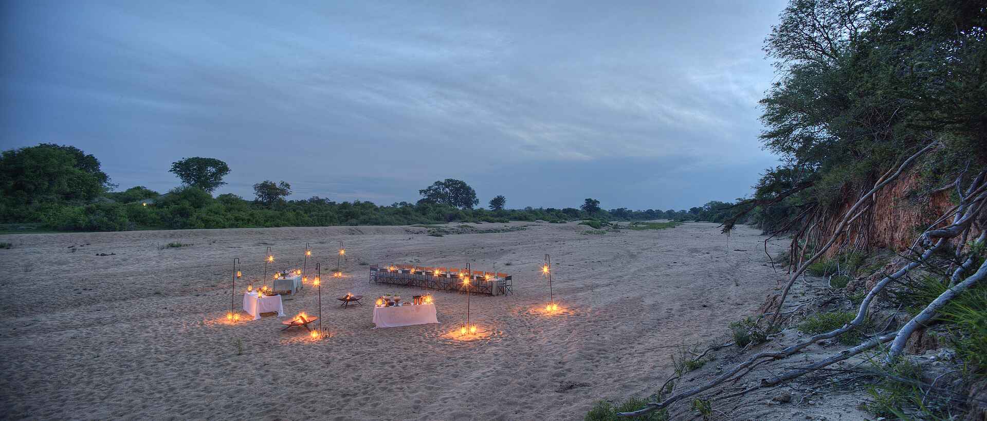 &Beyond, andBeyond, Krüger Nationalpark, Ngala Tented Camp, Timbavati River, Abend, Dekoration, Essen, Fluss, Flussbett, Gedeck, Lagerfeuer, Laternen, Service, Tisch, Trinken, Afrikarma, Afrikarma Safaris, Afrikarma Safaris - Wildnis. Hautnah., Afrikarma.de, Wildnis. Hautnah.