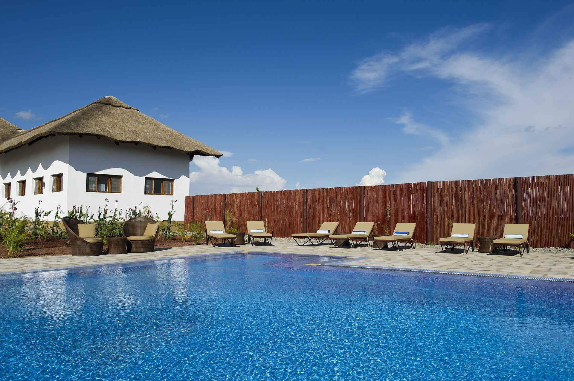 farmhouse valley lodge, ngorongoro conservation area, tanganyika wilderness camps, korbstühle, liegestühle, swimmingpool, afrikarma, afrikarma safaris, afrikarma safaris - wildnis. hautnah., afrikarma.de