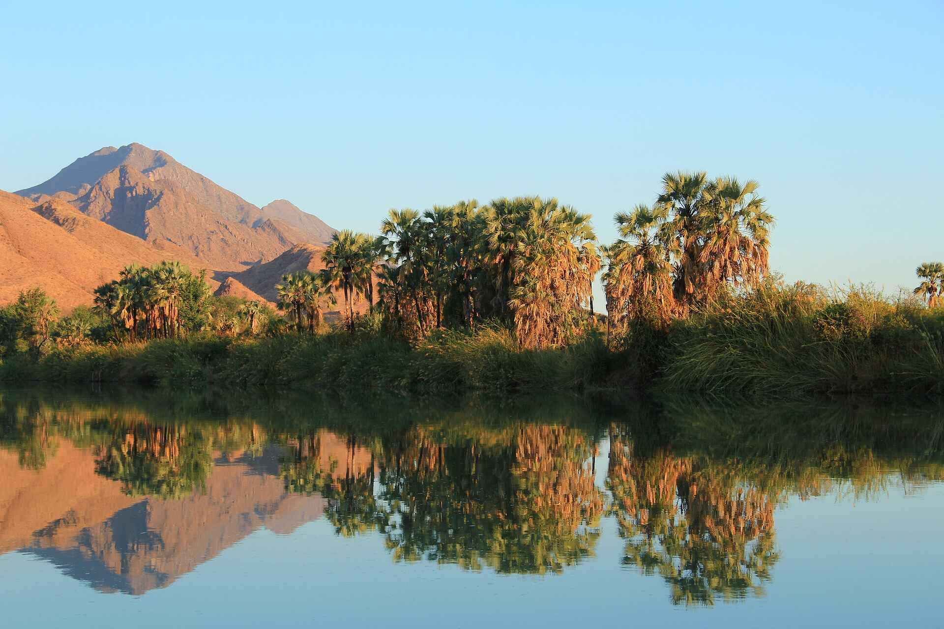 Abgeschiedenheit, afrikarma, afrikarma.de, buchen, Damaraland, Entspannung, Erholung, Fly In, Himba, Himba Dorf, Himba-Stamm, Information, Kultur, Kunene, Kunene Region, Kunene River, Marienfluss, Marienfluss Region, Namibe, Namibia, Nordnamibia, Nordwestnamibia, Okahirongo, Okahirongo Lodges and Camps, Okahirongo River Camp, Otupambua, Otupambua Stromschnellen, Privatsphäre, Reise, Reisen, Reiseveranstalter, River Camp, Ruhe, Safari, südliches Afrika, Urlaub, www.afrikarma.de, Fluss, Landschaft, Spiegelung, Wasser