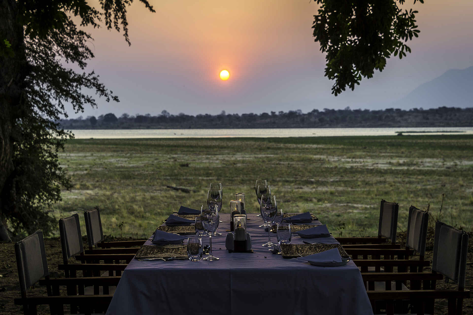 Little Ruckomechi Camp: Esstisch mit Blick auf das Sambesi-Ufer Little Ruckomechi Camp, Mana Pools National Park, Sambesi, Wilderness Safaris, Blick, Esstisch, Sonnenuntergang, Afrikarma, Afrikarma Safaris, Afrikarma Safaris - Wildnis. Hautnah., Afrikarma.de