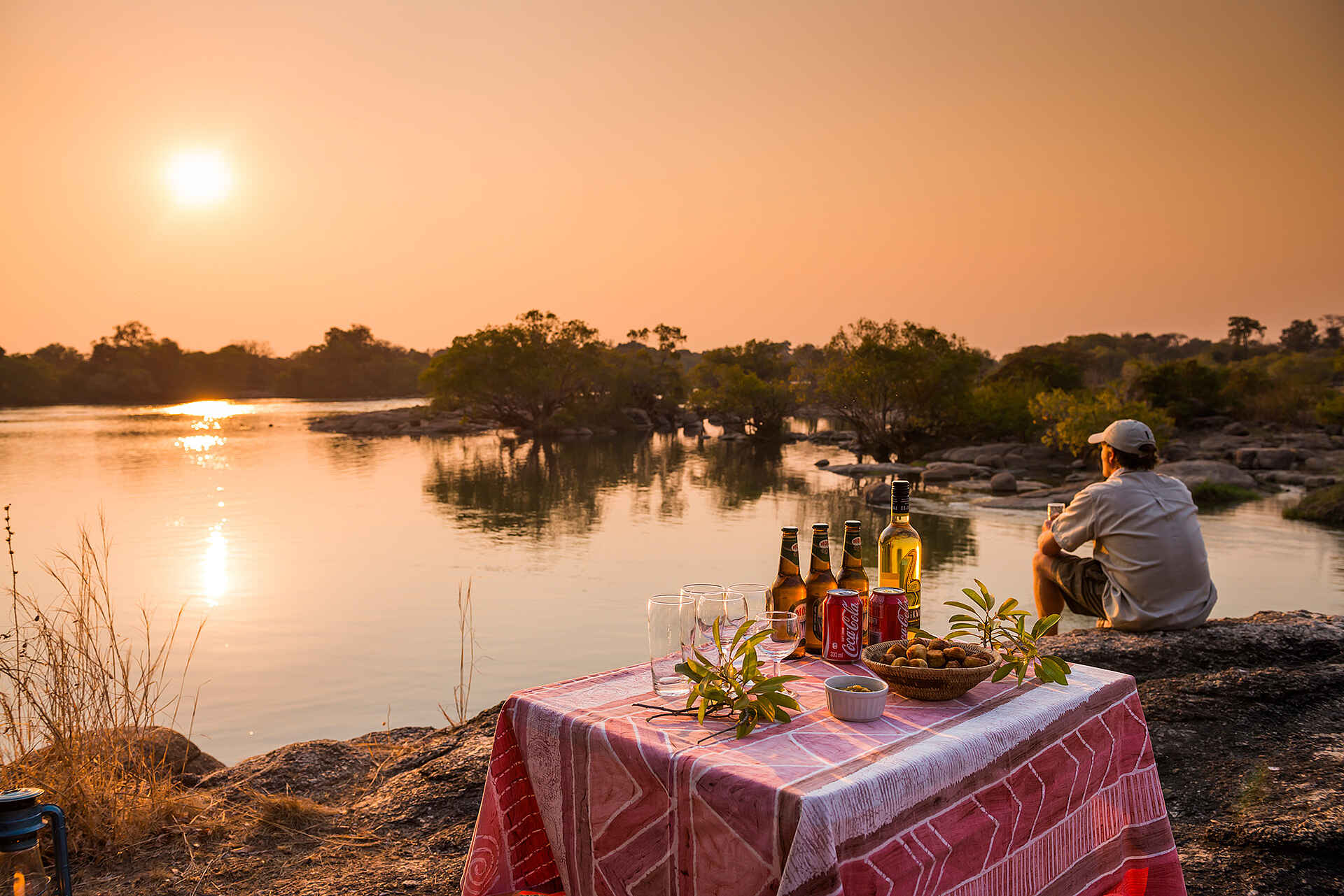 KaingU Safari Lodge: Sundowner auf Felsen am Fluss
