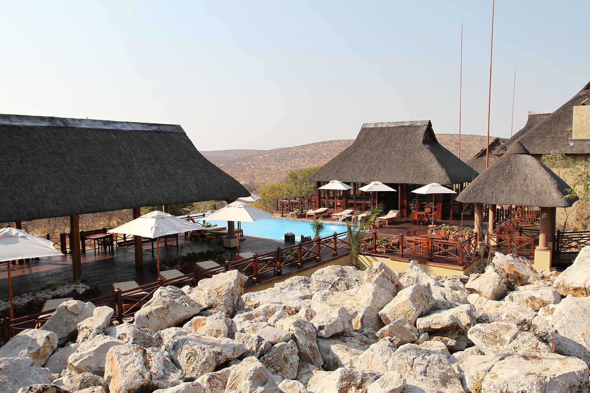 Epacha Game Lodge & Spa, Epacha Private Game Reserve, Epacha Wildtierreservat, Etosha Nationalpark, Infinity Pool, Liegestühle, Poolbar, Sonnendeck, Sonnenschirme, Afrikarma, Afrikarma Safaris, Afrikarma Safaris – Wildnis. Hautnah., afrikarma.de