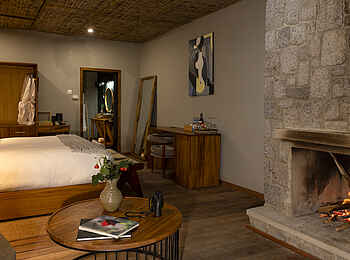Sambora Kinigi Lodge: Schlafbereich mit Kamin