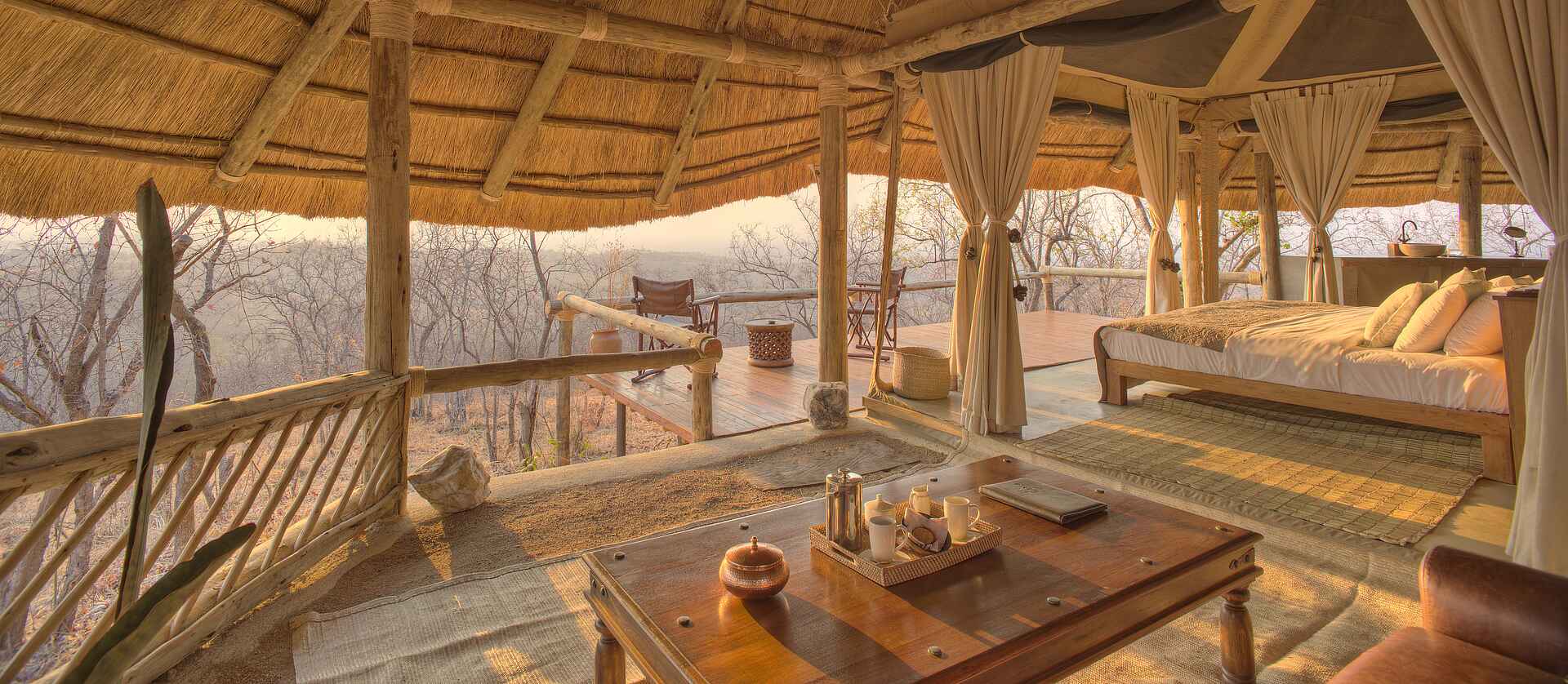 Ikuka Safari Camp: Blick von der Lounge in einem Gästezelt Chloe Sheridan-Johnson, Ikuka Safari Camp, Mark Sheridan-Johnson, Ruaha National Park, Ausblick, Beistelltisch, Doppelbett, Gästezelt, Himmelbett, Ledersofa, Private Lounge, Private Terrasse, Sofa, Afrikarma, Afrikarma Safaris, Afrikarma Safaris – Wildnis. Hautnah., afrikarma.de