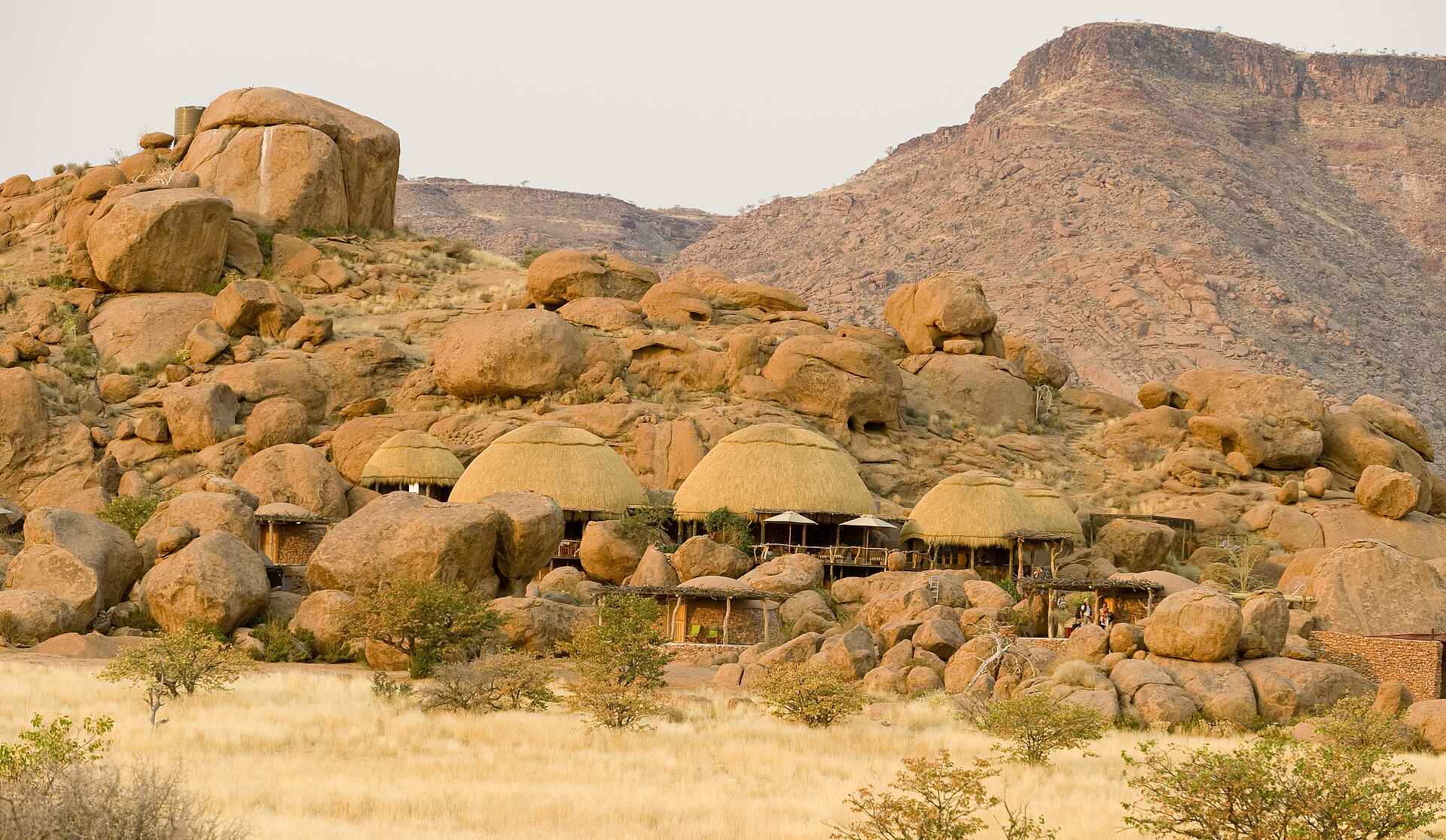 Afrikarma, Afrikarma Safaris, Afrikarma.de, Brandberg, Camp Kipwe, Damaraland, Felsen, Gästechalet, Gesamtansicht, Granit, Hauptgebäude, Strohdach, Veranda, Mowani Collection