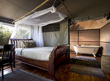 Linyanti Bush Camp: Doppelbett mit Moskitonetz Linyanti Bush Camp: Doppelbett mit Moskitonetz