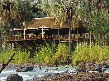 Epupa Falls Lodge: Der Hauptbereich ragt fast direkt über den Flusslauf