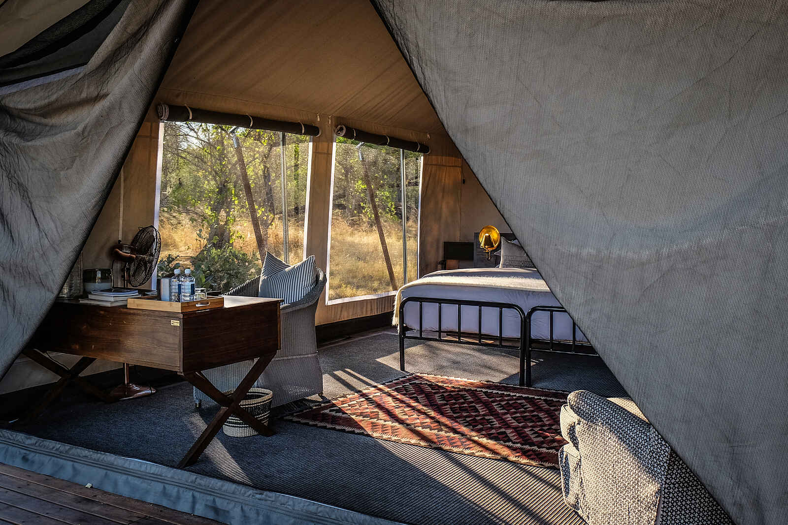 Little Machaba Camp: Interieur eines Gästezelts mit kleinem Holzschreibtisch und Doppelbett Little Machaba Camp: Interieur eines Gästezelts mit kleinem Holzschreibtisch und Doppelbett