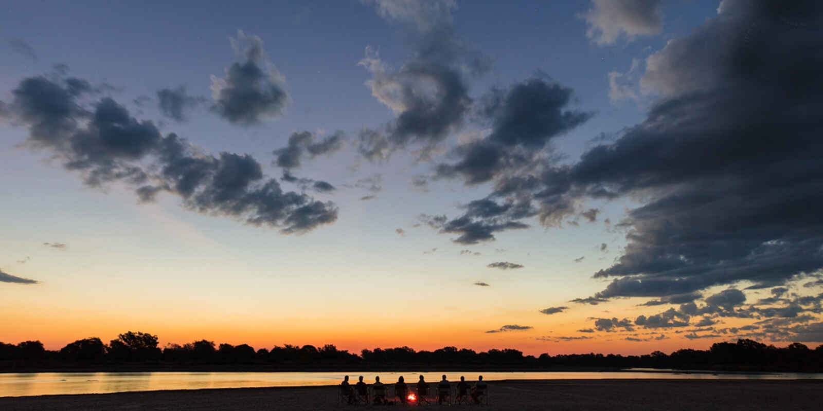 Luambe Camp: Ein Sundowner auf einer Sandbank mit Lagerfeuer Luambe Camp: Ein Sundowner auf einer Sandbank mit Lagerfeuer