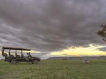 Kichwa Tembo Tented Camp: Safarifahrzeug unter dunklen Wolken Kichwa Tembo Tented Camp: Safarifahrzeug unter dunklen Wolken