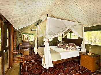 Zungulila Bushcamp: Gästebett und Teppiche Zungulila Bushcamp: Gästebett und Teppiche