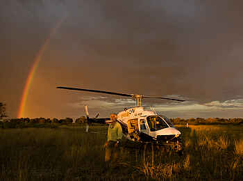 Duba Plains Camp: Dereck Joubert vor einem Hubschrauber
