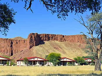 Namib Desert Lodge: Gästeunterkünfte vor versteinerten Sanddünen Namib Desert Lodge: Gästeunterkünfte vor versteinerten Sanddünen