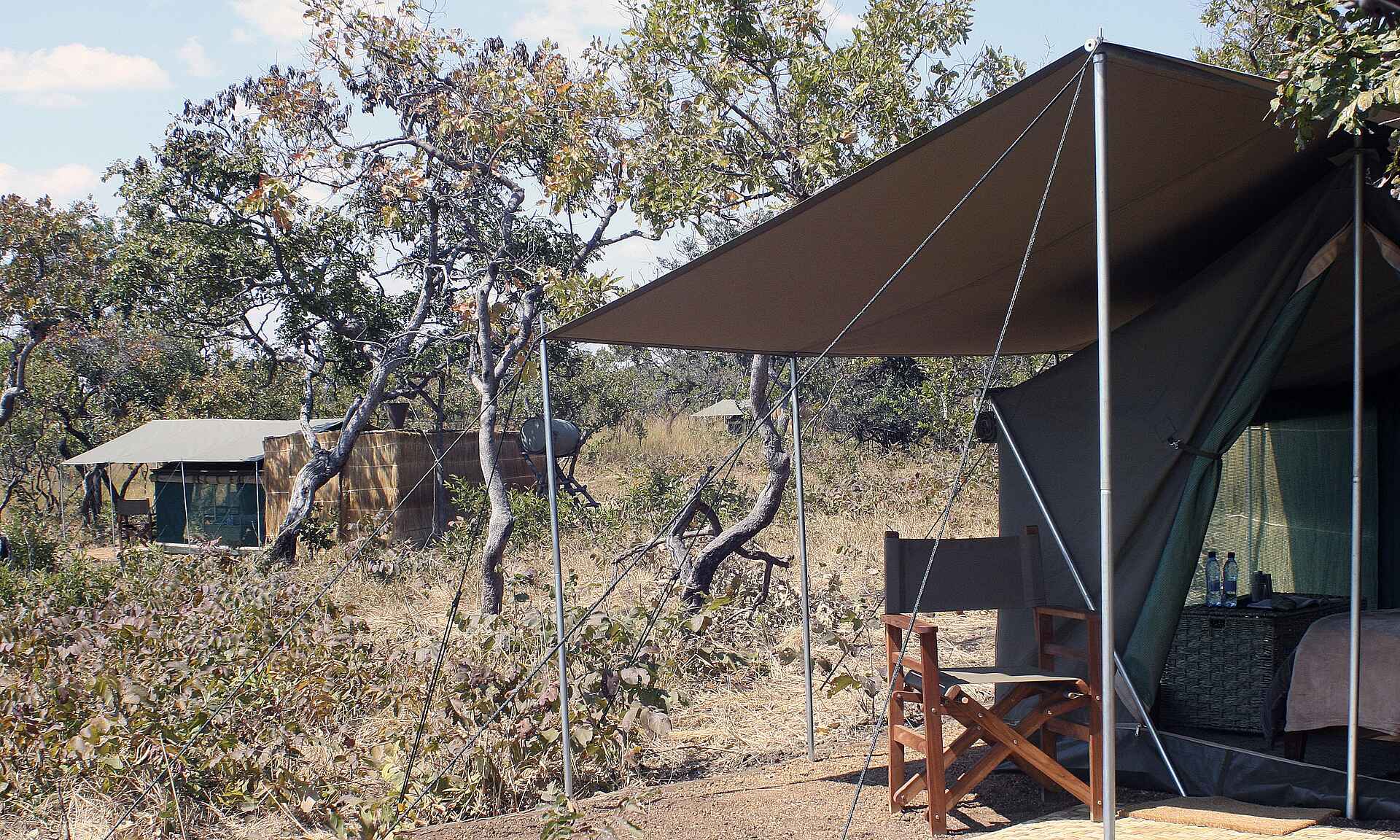 Musekese Camp: Gästezelt mit Vordach und Regiesessel Musekese Camp, Jeffery & McKeith Safaris, Phil Jeffery, Tyrone McKeith, Beobachtungsunterstand, Bird Watching, Busanga Plains, Chibemba Saltpan, Gästezelt, Kafue National Park, Kafue River, Lufupa Airstrip, Vogelbeobachtung, Vordach, Afrikarma, Afrikarma Safaris, Afrikarma.de