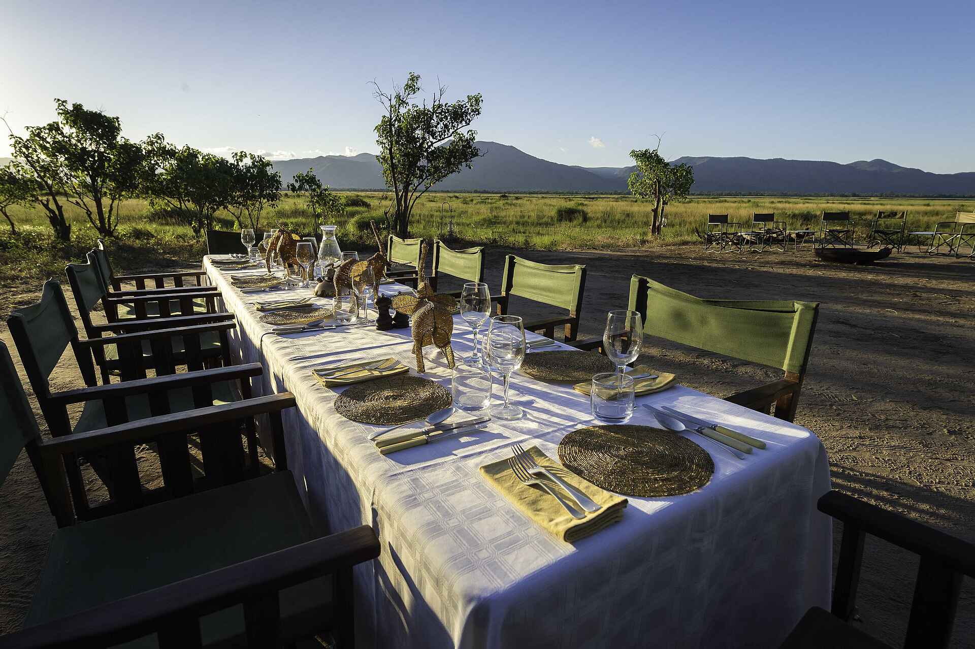 John's Camp, Mana Pools National Park, Mana Pools Nationalpark, Robin Pope Safaris, Sambesi, Simbabwe, The Mana Pools Safari Company, Zambezi River, Gedeckter Tisch, Lange Tafel, Mahlzeiten, Regiestühle, Speisebereich, Tisch, Afrikarma, Afrikarma Safaris, Afrikarma Safaris – Wildnis. Hautnah., afrikarma.de