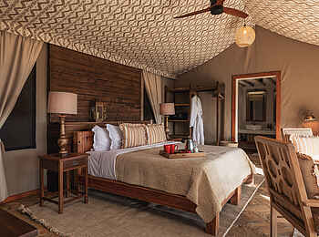Lewa Safari Camp: Familienunterkunft Doppelbett mit Blick ins Badezimmer