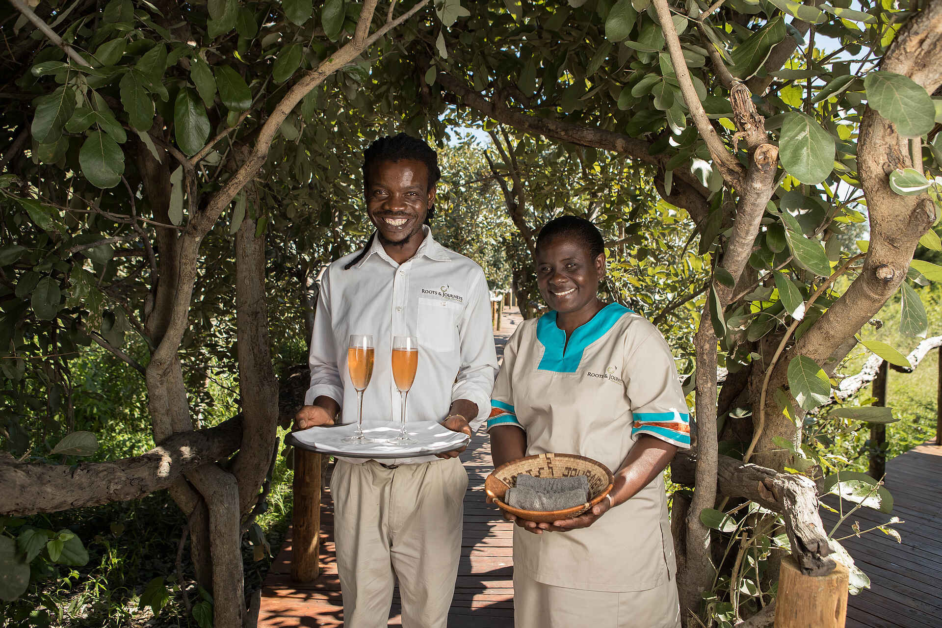 Afrikarma, Afrikarma Safaris, Afrikarma Safaris. Wildnis. Hautnah., Afrikarma.de, Bäume, Empfang, Handtücher, Personal, Sekt, Uniform, Sektempfang