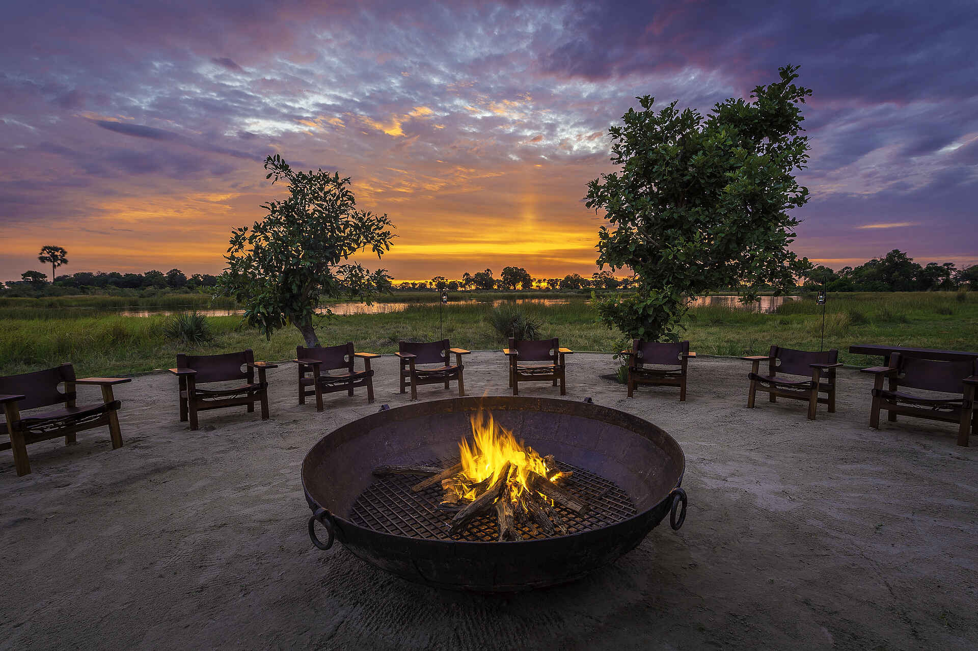 Qorokwe Camp: Boma Afrikarma Safaris, Afrikarma Safaris - Wildnis. Hautnah., Afrikarma.de, Glamping, NG 32, Okavango-Delta, Qorokwe Camp, Wilderness Safaris, Abendlicht, Boma, Feuerplatz, Afrikarma