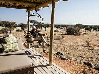 Otjimbondona Kalahari Lodge: Die Terrasse mit Hängesessel in der Villa Warthog